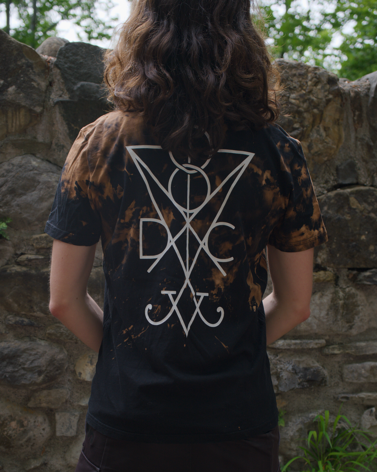 Person wearing a custom bleached black Dark Circles t-shirt with a white sigil on the back